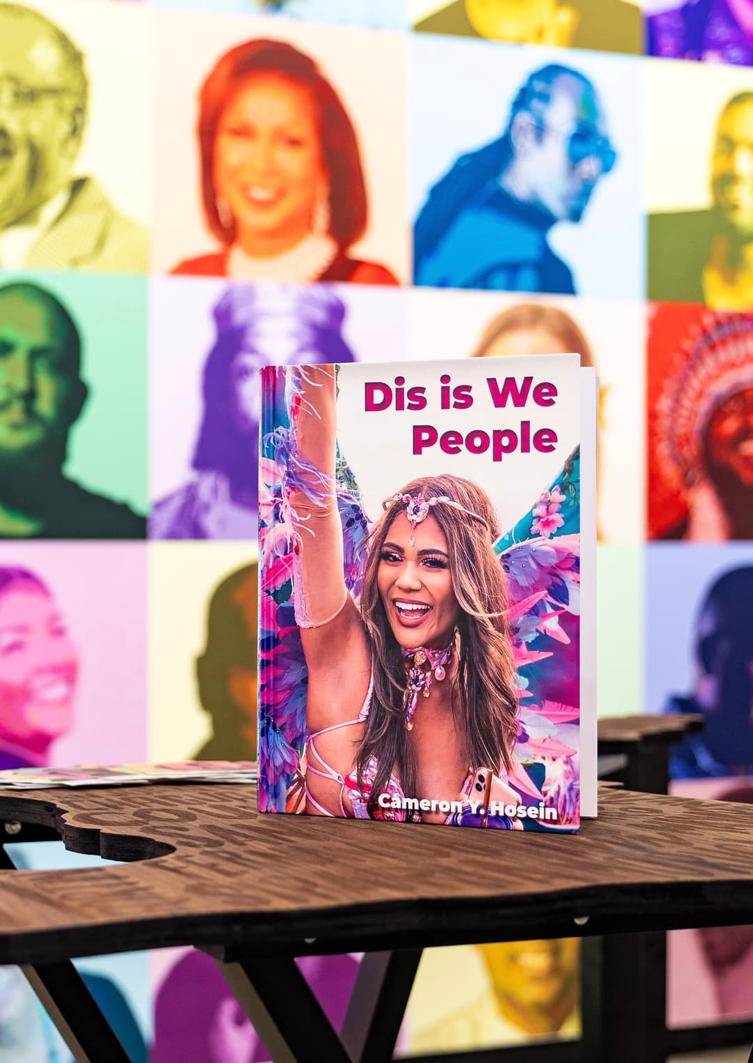Dis is We People magazine cover featuring carnival performer against the wall of creative portraits